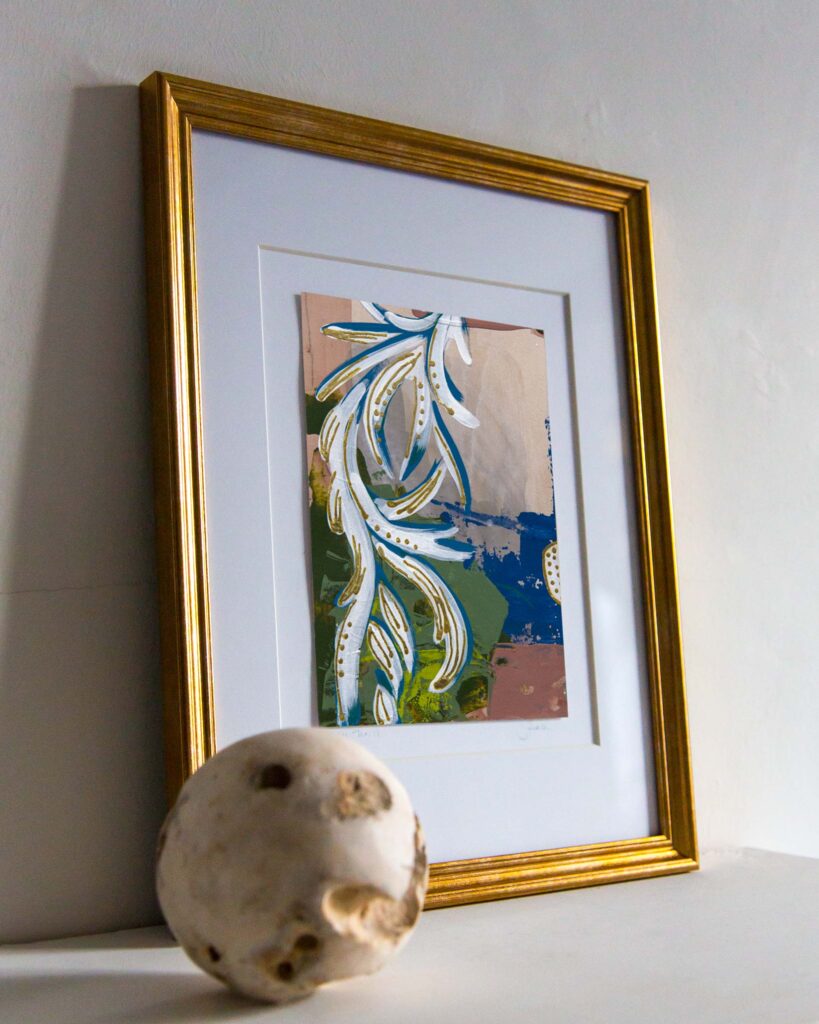 Angled mantel view of an abstract architectural painting by Teale Hatheway featuring a scrolling neoclassical rinceau motif in white and blue with gold leaf embellishments. The stylized foliate tendrils sweep diagonally across a layered background of olive green, cobalt blue, and soft parchment, evoking classical ornament through contemporary brushwork and color.
